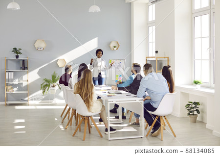 Black female coach make flip chart presentation for businesspeople Black female coach make flip chart presentation for businesspeople 88134085