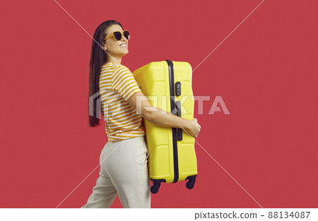 Smiling woman with baggage ready for summer vacation Smiling woman with baggage ready for summer vacation 88134087
