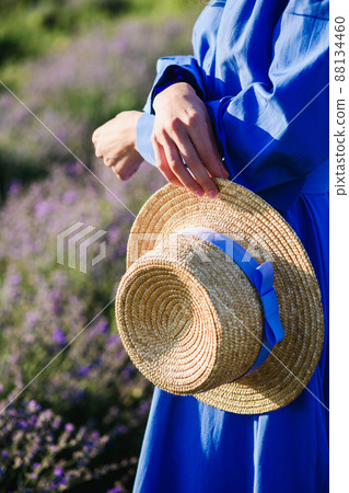 Girl holding a straw hat in hands 88134460