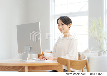 A woman who operates a personal computer at home 88134655