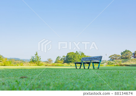 [日本]福生市，多摩川沿岸綠草如茵的公園裡的長椅，湛藍的天空 88134674