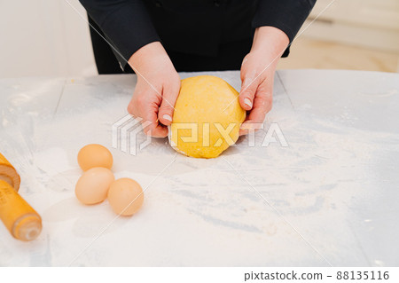 women's hands knead dough. flour and eggs on table women's hands knead dough. flour and eggs on table 88135116