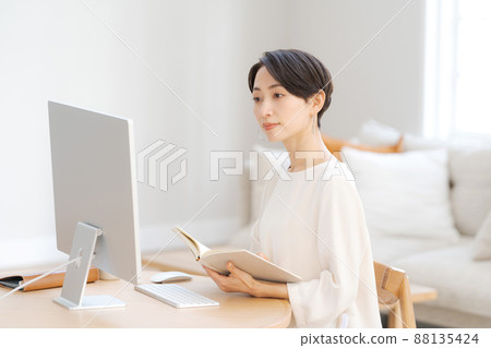 Woman operating a personal computer Woman operating a personal computer 88135424