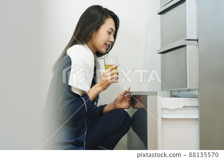 一個穿著睡衣打開冰箱的女人 88135570