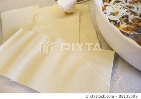 Cooking traditional homemade lasagna. Lasagna sheets NEAR A ROUND CERAMIC BAKING DISH Top View 88135599