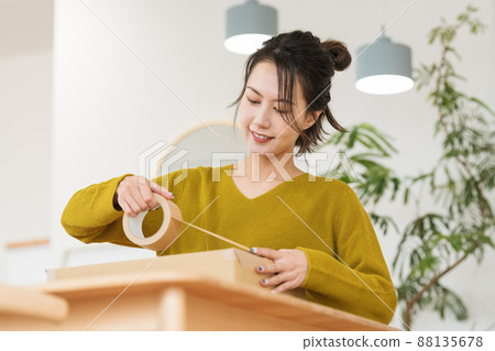 A woman who puts gum tape on cardboard 88135678