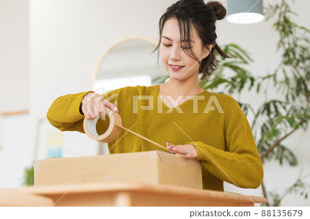 A woman who puts gum tape on cardboard 88135679