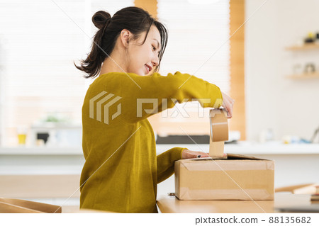 A woman who puts gum tape on cardboard 88135682