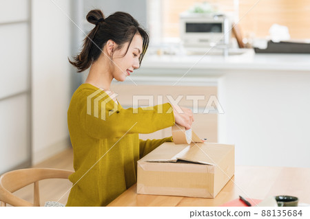 A woman who puts gum tape on cardboard 88135684