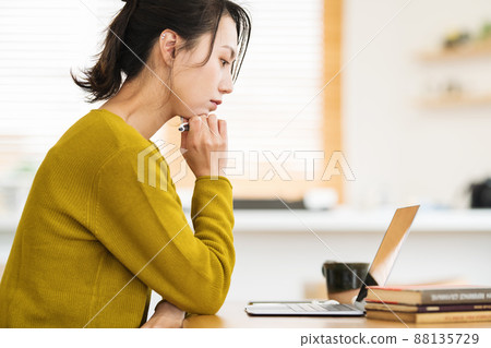 A woman teleworking in her living room A woman teleworking in her living room 88135729