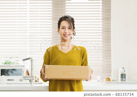 Woman with cardboard at home Woman with cardboard at home 88135734