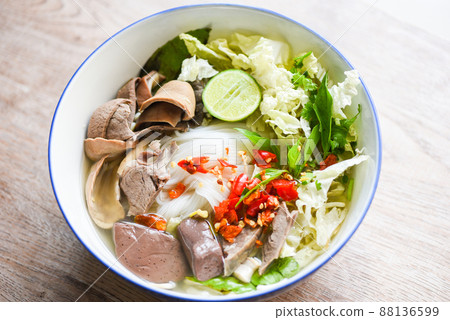 Thai rice vermicelli noodle with clear soup and fresh vegetable set with lemon sprouts bean pepper chili sauce Thai traditional menu food, Noodle soup bowl pork blood pudding and pork offal Thai rice vermicelli noodle with clear soup and fresh vegetable set with lemon sprouts bean pepper chili sauce Thai traditional menu food, Noodle soup bowl pork blood pudding and pork offal 88136599