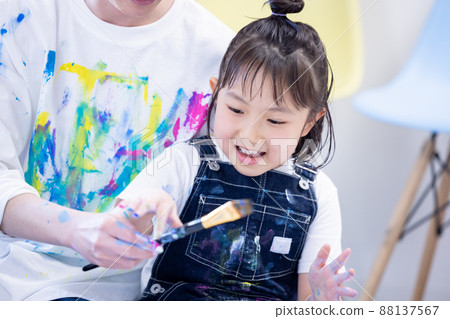 一個在大畫紙上用顏料畫畫的女孩 88137567