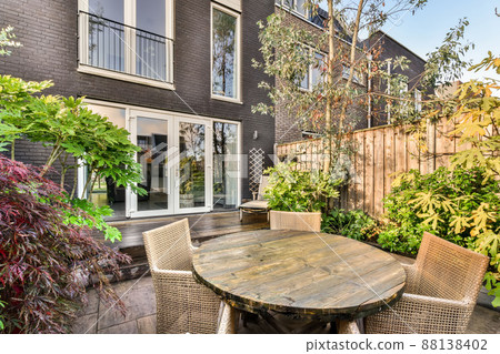 The backyard of a modern house with wooden floors and a small sitting area The backyard of a modern house with wooden floors and a small sitting area 88138402