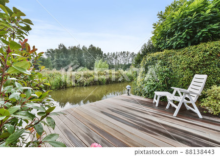 Mind-blowing wooden walkway surrounded by trees leading to the canal Mind-blowing wooden walkway surrounded by trees leading to the canal 88138443