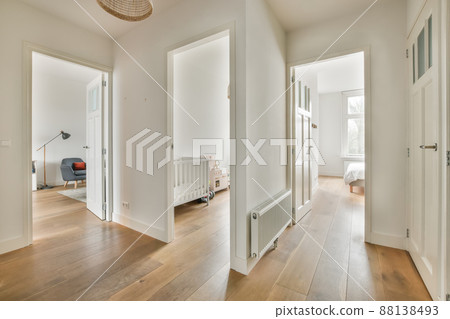 The interior of a spacious corridor in the apartment, in white with parquet floor The interior of a spacious corridor in the apartment, in white with parquet floor 88138493