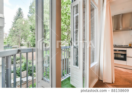 Access to a small balcony with wooden doors and a panoramic window in a cozy house 88138609