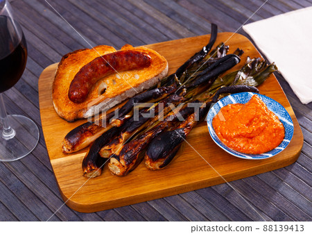 Appetizing calsot served with Romesco sauce and sausage butifarra 88139413