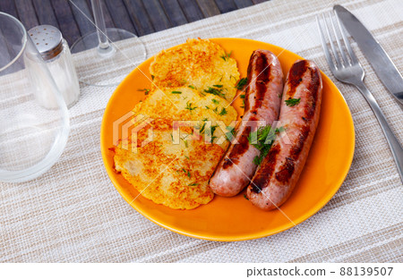 Just cooked potato pancakes with roasted sausages on plate Just cooked potato pancakes with roasted sausages on plate 88139507