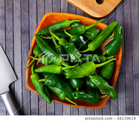 Plate of fresh padron peppers and knife on wooden table 88139619