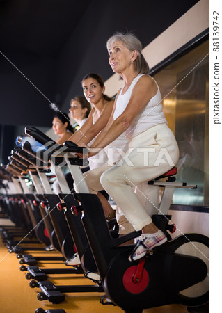 Mature woman taking cycling class at gym 88139742