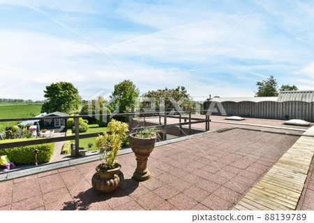 Spacious veranda overlooking a huge field and outdoor trees Spacious veranda overlooking a huge field and outdoor trees 88139789