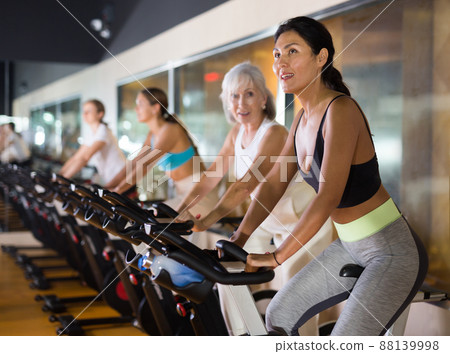Woman on stationary bike workout in gym 88139998