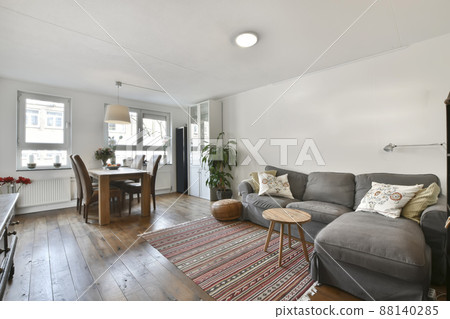 Relaxation room with comfortable, soft, gray sofa and houseplants Relaxation room with comfortable, soft, gray sofa and houseplants 88140285