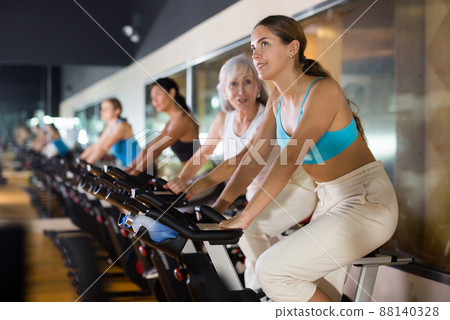 Woman taking indoor cycling class at gym 88140328