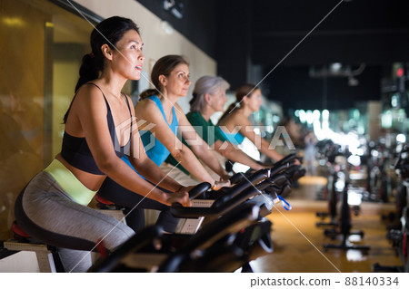 Woman on stationary bike workout in gym Woman on stationary bike workout in gym 88140334