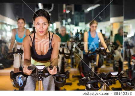Woman on stationary bike workout in gym Woman on stationary bike workout in gym 88140358
