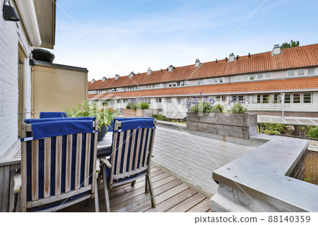 Beautiful balcony with wooden chair with blue cushions Beautiful balcony with wooden chair with blue cushions 88140359
