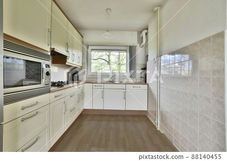 Compact equipped kitchen in a minimalist style with a gas stove 88140455