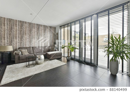 Living room with a large sofa with access to a spacious backyard in a new house Living room with a large sofa with access to a spacious backyard in a new house 88140499