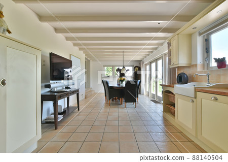 Spacious kitchen combined with dining area. Wooden table with leather chairs 88140504
