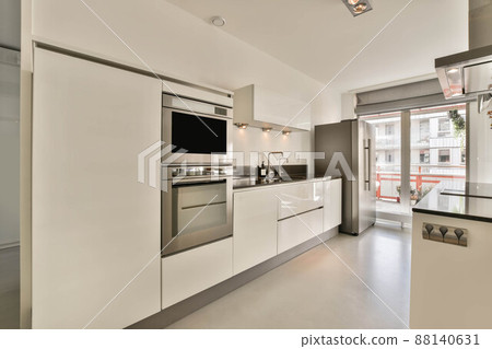 Spacious and cozy minimalist open-plan kitchen in a modern house Spacious and cozy minimalist open-plan kitchen in a modern house 88140631