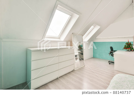 Modern room in the attic of a house with white furniture and white walls Modern room in the attic of a house with white furniture and white walls 88140737