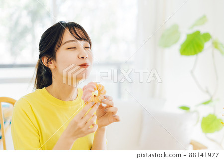 A woman eating a donut 88141977