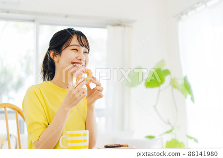 A woman eating a donut 88141980
