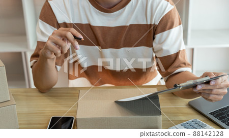 Online shopping concept the selling agent writing down a product report and checking his product in the parcel 88142128