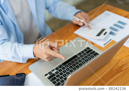 Business analyst concept the accountant using a calculator to estimate the amount of profits 88142136