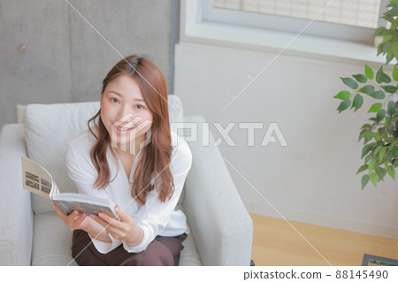 Bird's-eye view_Woman who raises her face from a book and smiles 1 Bird's-eye view_Woman who raises her face from a book and smiles 1 88145490