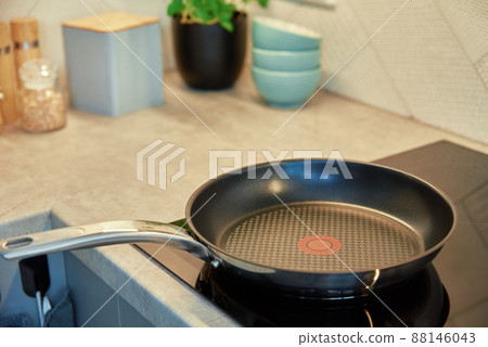 Frying pan on induction hob at kitchen Frying pan on induction hob at kitchen 88146043