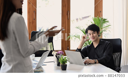 Handsome male business team leader listening attentively terms of transaction from business partner. 88147033