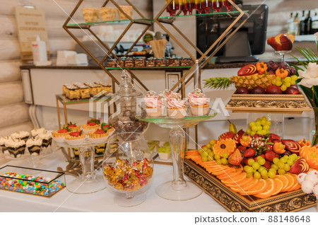 Different fresh fruits on wedding buffet table. Wedding reception catering table with different fruits. Catering table with different kind of fruits Different fresh fruits on wedding buffet table. Wedding reception catering table with different fruits. Catering table with different kind of fruits 88148648