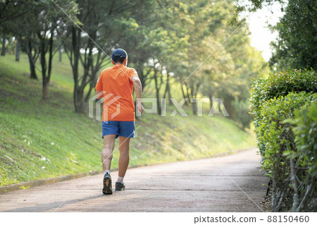 Man runner jogging in a park. 88150460