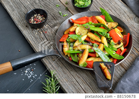 Roasted vegan finger-shaped potato dumplings with fresh vegetables in an iron frying pan Roasted vegan finger-shaped potato dumplings with fresh vegetables in an iron frying pan 88150678