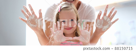 Mom and daughter show hands in flour, close-up 88150715