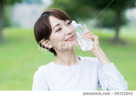 A woman who cools his head with a plastic bottle A woman who cools his head with a plastic bottle 88152042