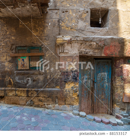 Grunge stone bricks wall with Broken wooden door and closed broken window in abandoned district 88153317